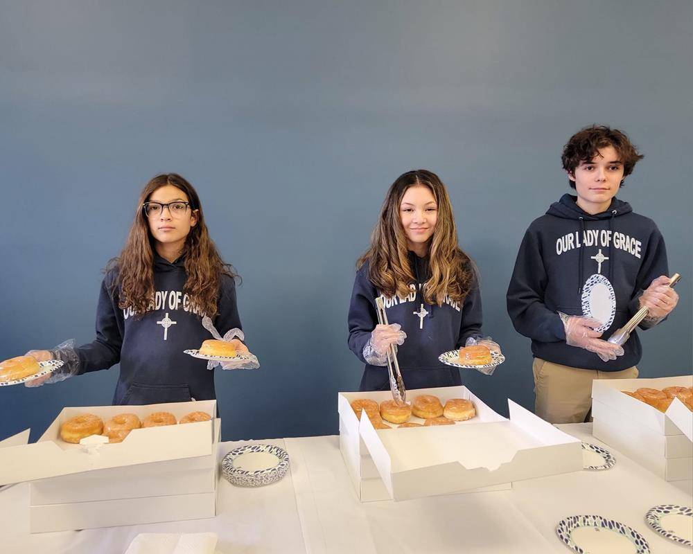 Students at Our Lady of Grace School hand out treats after Mass to start Catholic Schools Week.