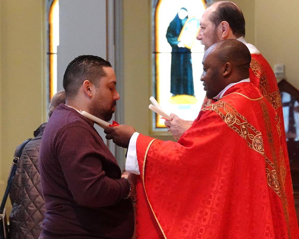 Father Melchesideck Yumo and Deacon Rich McCarron imparted the traditional throat blessing for the Feast Day of St. Blaise at the 9 a.m. Mass at St. Mark Church in Huntersville.