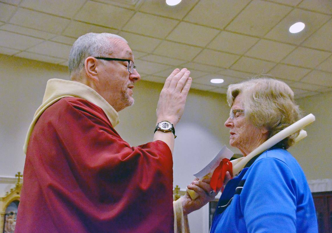 Father Eric Kowalski blesses his parishioners’ throats on the Feb. 3 feast of St. Blaise.