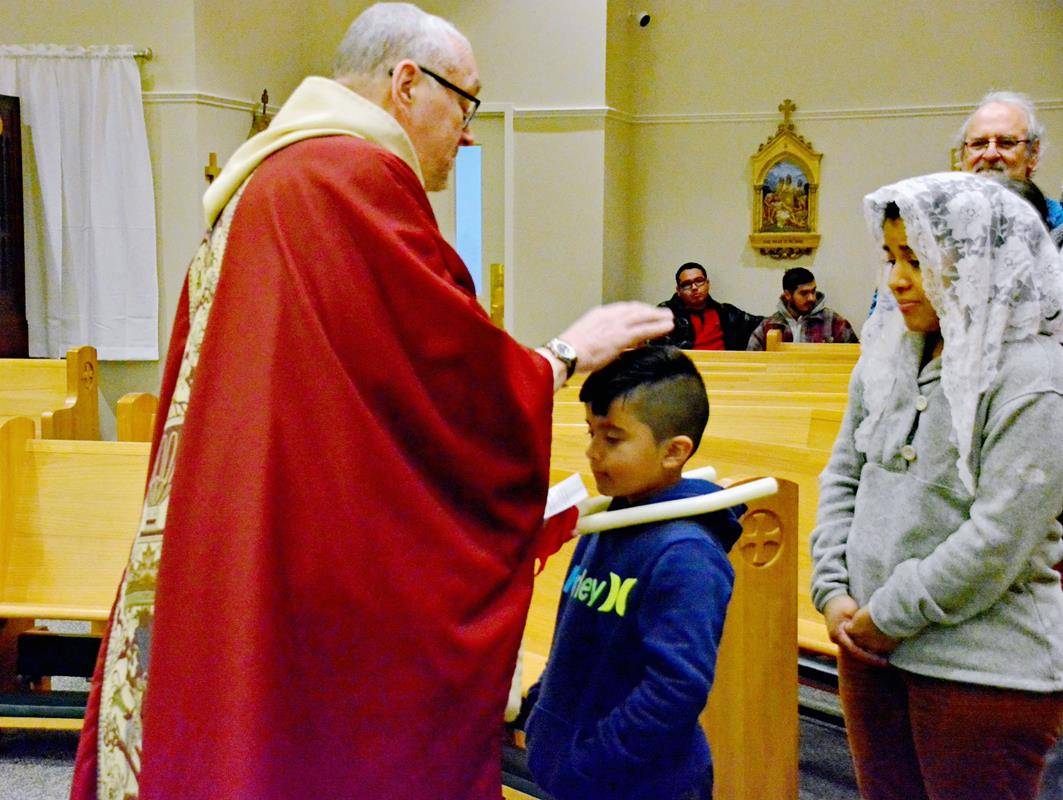 Father Eric Kowalski blesses his parishioners’ throats on the Feb. 3 feast of St. Blaise.
