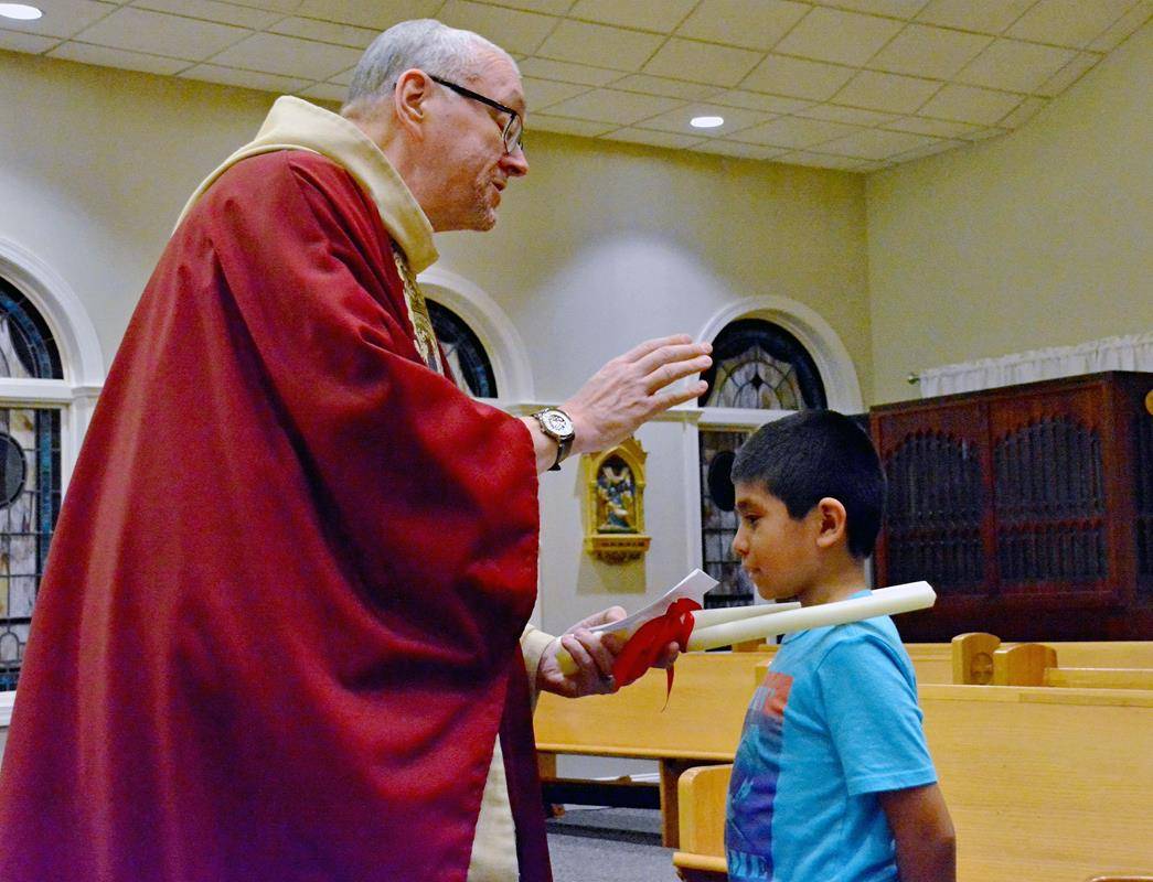 Father Eric Kowalski blesses his parishioners’ throats on the Feb. 3 feast of St. Blaise.
