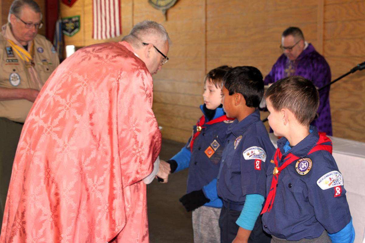 Monsignor Winslow gives out Catholic religious emblems to Cub Scouts who have earned their Light of Christ or Parvuli Dei awards over the past year. (Photo by Patricia Guilfoyle)