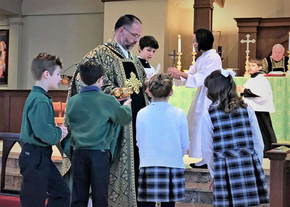 Students at St. Mark School opened Catholic Schools week by participating in the Jan. 29 11 a.m. Mass at the Huntersville parish. Students served as lectors, altar servers, gift presenters and singers in the choir.  (Photos provided by Amy Burger)
