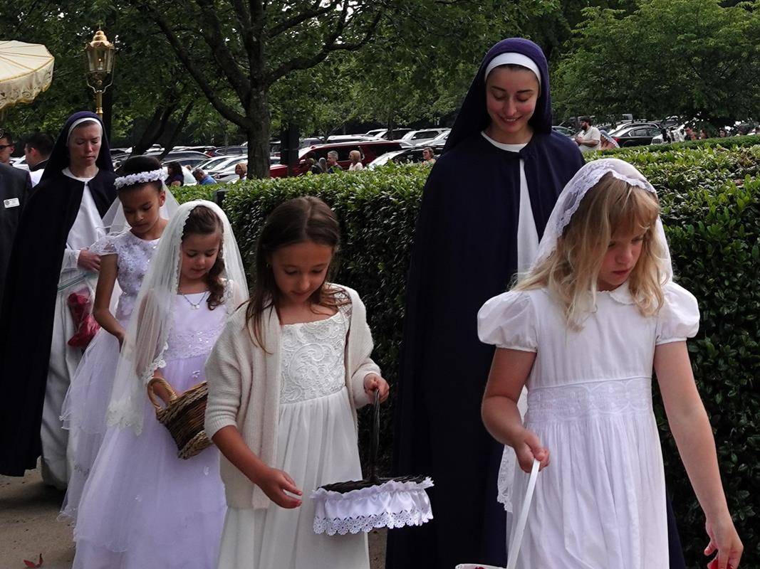 Sisters from the Daughters of the Virgin Mother organized the flower girls with rose petals and Diocese seminarians assisted and served at both Masses and Processions. (Photos by Amy Burger)