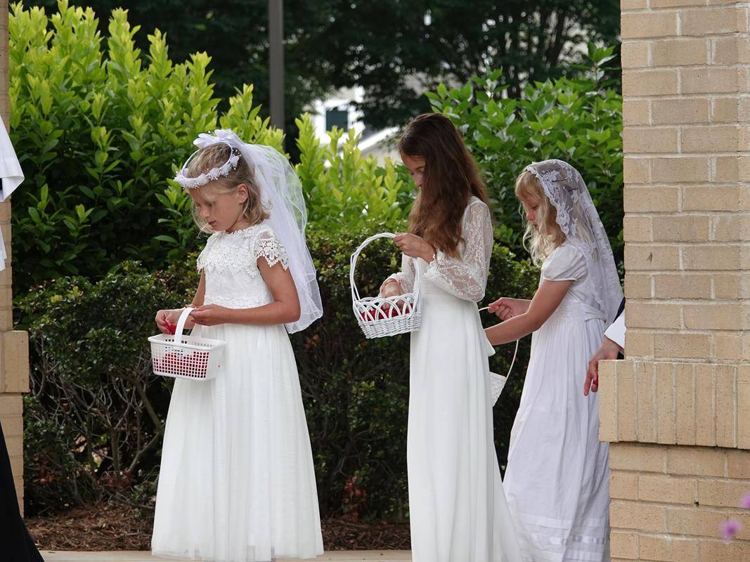 Sisters from the Daughters of the Virgin Mother organized the flower girls with rose petals and Diocese seminarians assisted and served at both Masses and Processions. (Photos by Amy Burger)