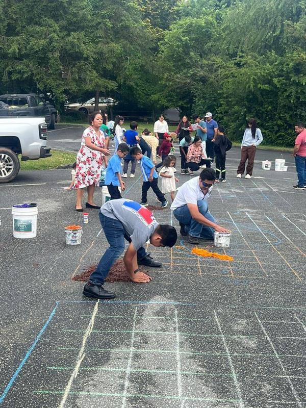 The faithful made colorful flower carpets to receive the Eucharist Procession at St Francis of Assisi in Franklin. They started working early in the morning.