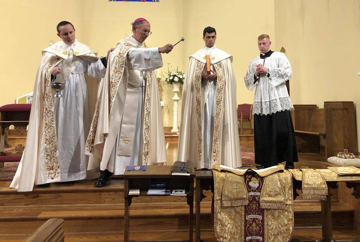 Bishop Peter Jugis blesses the vestments of Peter Rusciolelli, a parishioner of St. Patrick Cathedral who is being ordained to the priesthood Saturday.