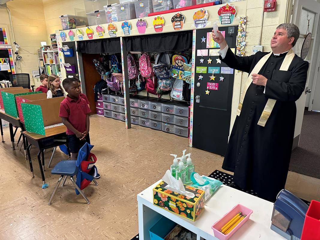 Father Brandon Jones led St. Ann School and parish congregation in a consecration of the school and the 2023-24 school year to the Immaculate Heart of Mary after the Aug. 25 Mass. Father Jones then blessed the school with holy water. 