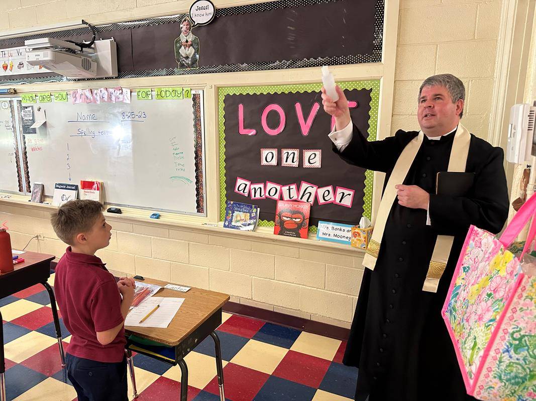 Father Brandon Jones led St. Ann School and parish congregation in a consecration of the school and the 2023-24 school year to the Immaculate Heart of Mary after the Aug. 25 Mass. Father Jones then blessed the school with holy water. 
