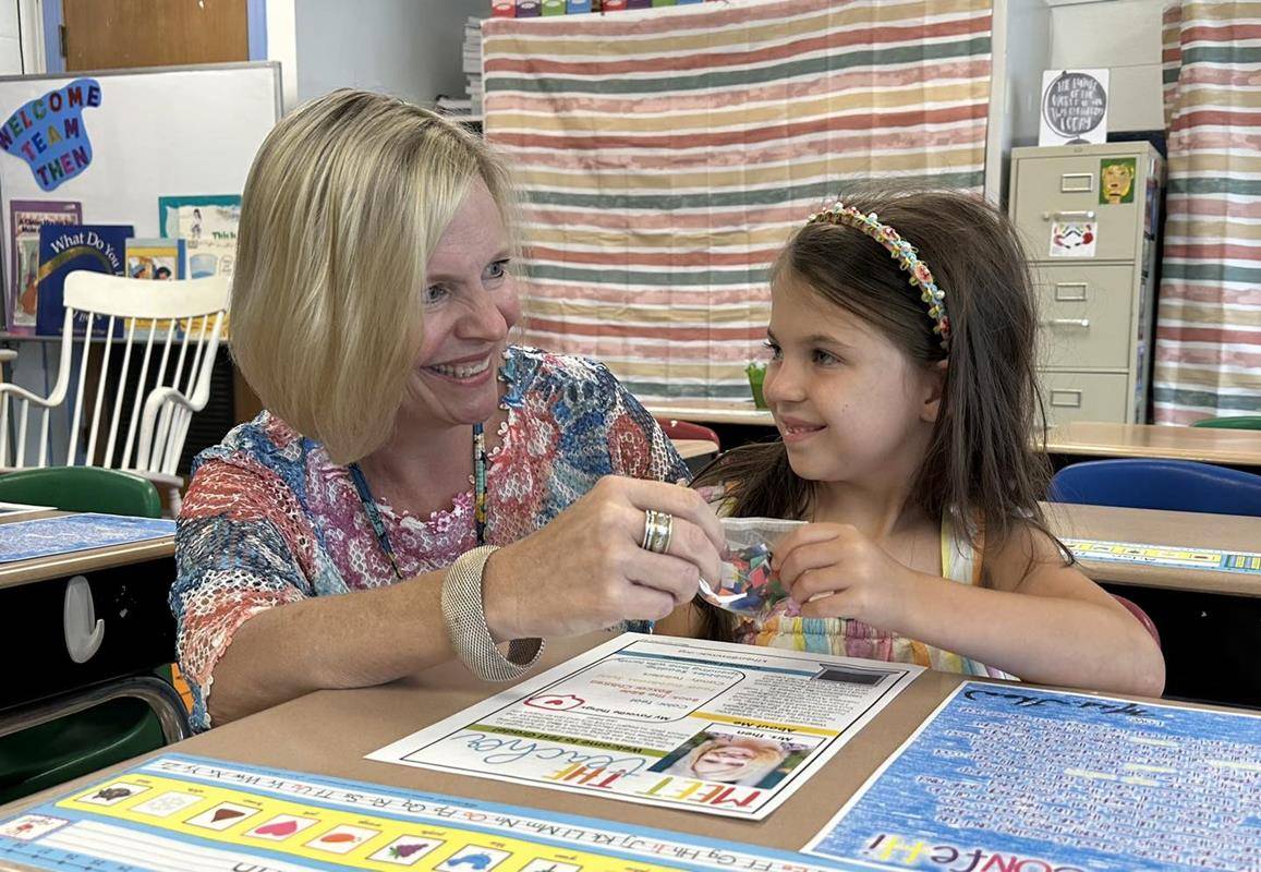 First grader Sophia receives “Ready Confetti” from Mrs. Then during Meet the Teacher at Immaculata School.