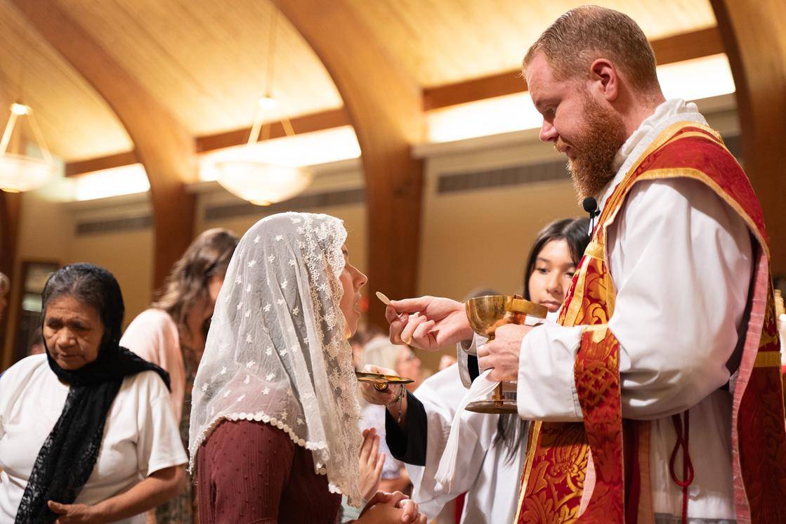 Father Carter offers Communion to parishioners.