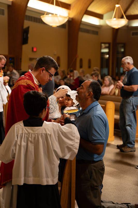 Father Christopher Brock offers Communion to the faithful.