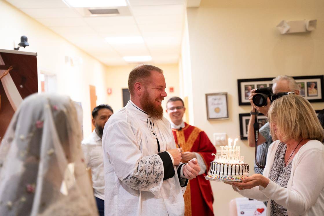 Father Noah Carter, pastor of Holy Cross, shares a birthday with his parish. Parishioners celebrated his special day as well.