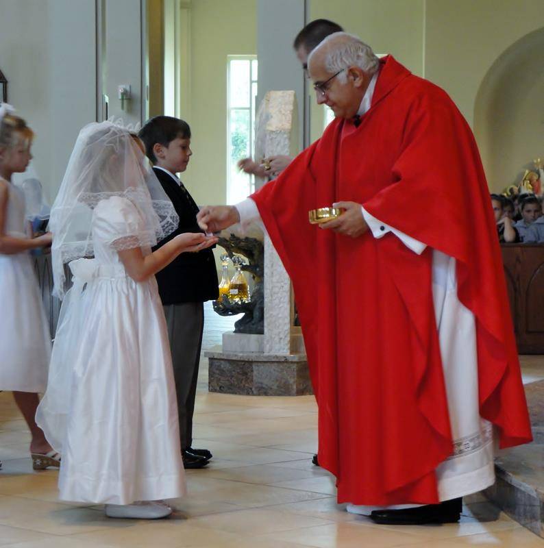 Msgr. Bellow pictured in 2011 celebrating a Mass for children receiving their first Holy Communion at St. Mark Church