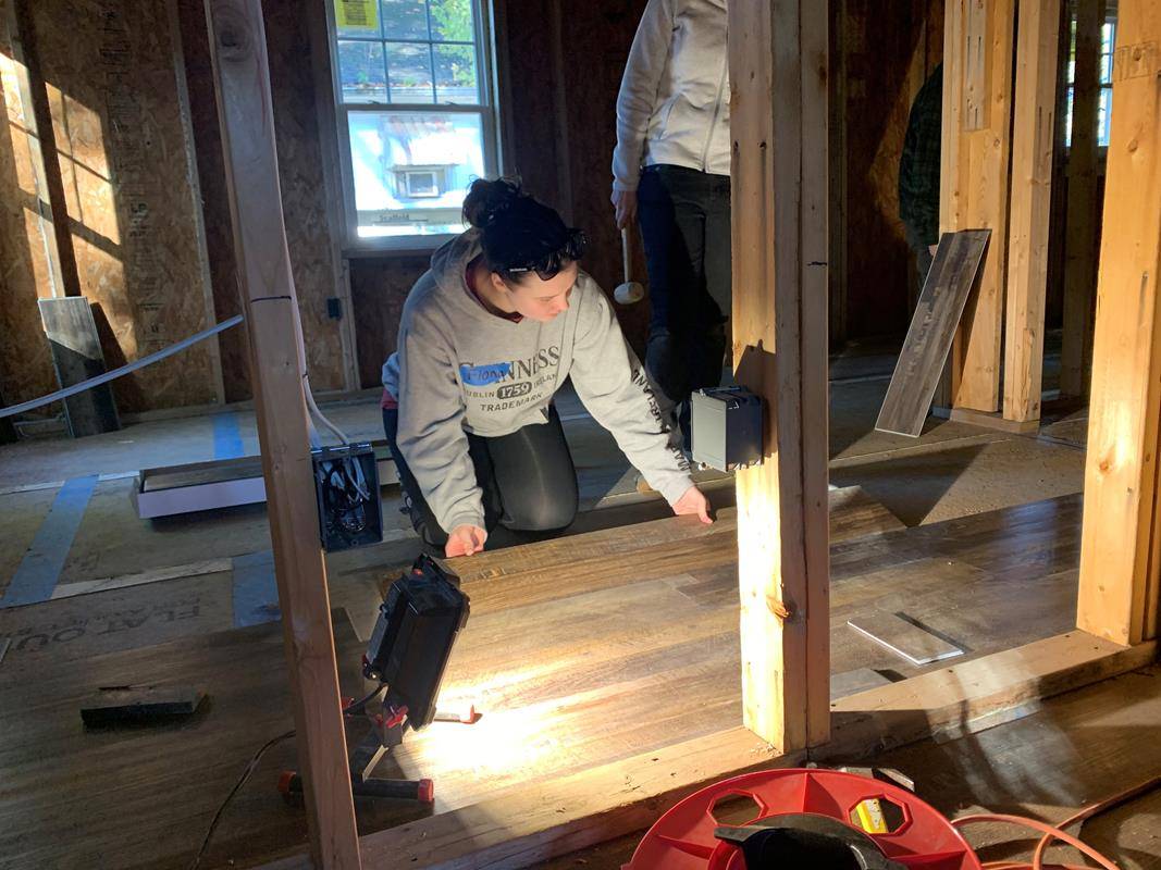 Winston Salem's Frassati young adult group volunteers to install flooring at a Habitat for Humanity home in eastern Winston-Salem.