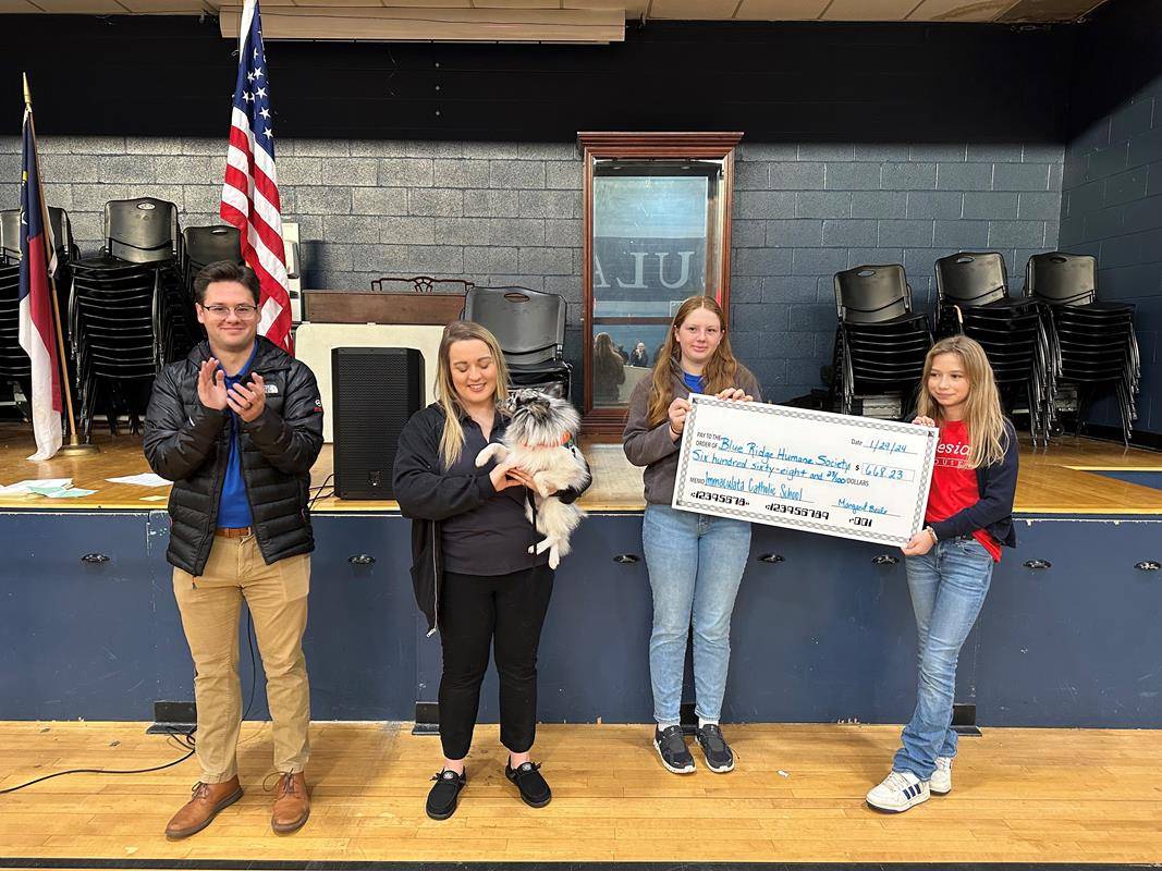 Members of Immaculata Catholic School student council presented a check for $668.23 to Andrew James, left, and Monica Garren from Blue Ridge Humane Society. 