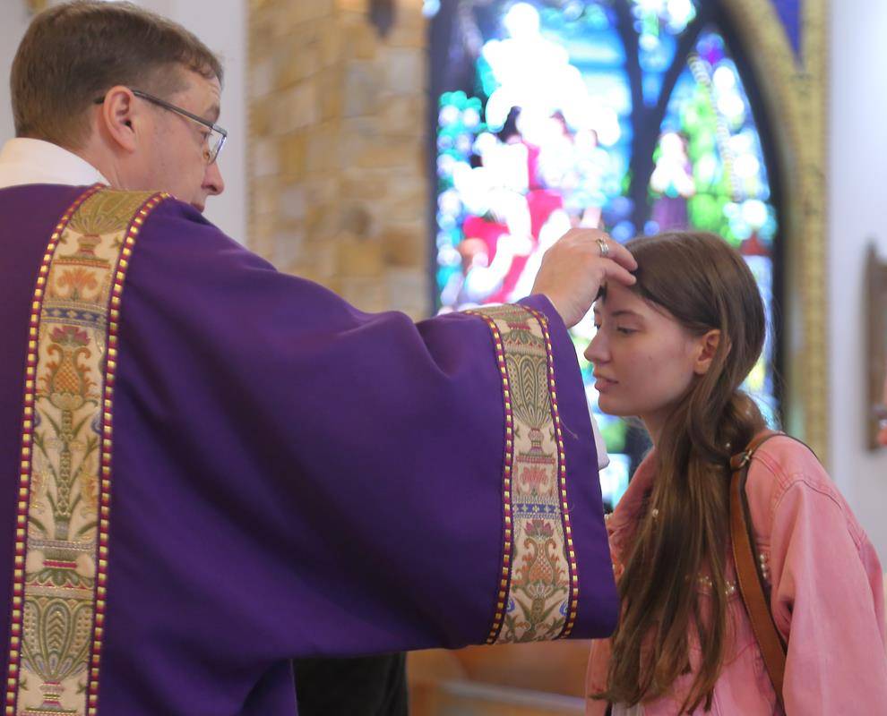 Deacon Dave Faunce distributed blessed ashes on Ash Wednesday, after the 12:10pm Mass, at Immaculate Conception Catholic Church, Forest City. (Giuliana Polinari Riley)