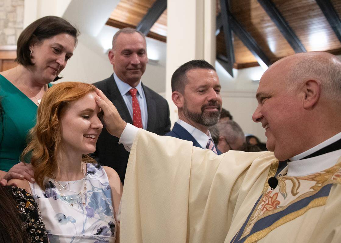 Monsignor Anthony Marcaccio confirms Elina Margeviciute, a former atheist, at St. Pius X Church in Greensboro.