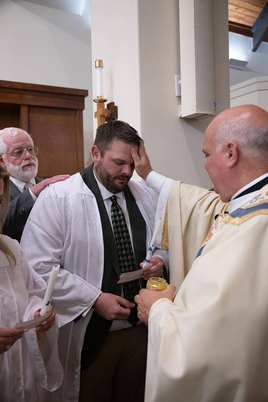 Monsignor Anthony Marcaccio confirms new Catholics at the Easter Vigil Mass March 30.