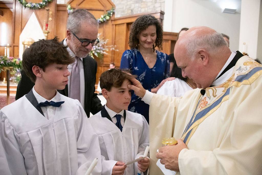 Monsignor Anthony Marcaccio confirms new Catholics at the Easter Vigil Mass March 30.
