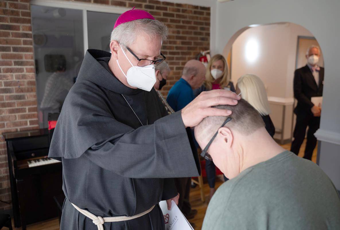 Charlotte Bishop-Elect Michael Martin, OFM Conv., blesses Holy Angels resident Mark during an April 9 visit to the Diocese of Charlotte following the Vatican's announcement that he will succeed Bishop Peter Jugis.
