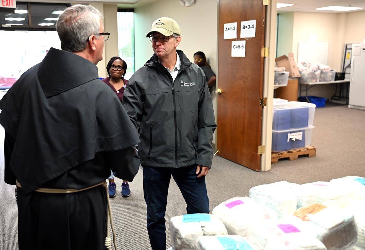 Bishop-Elect Michael Martin, OFM Conv., greets a volunteer at Catholic Charities' food pantry that operates inside the Diocese of Charlotte Pastoral Center. The Atlanta priest was appointed the fifth Bishop of Charlotte on April 9.