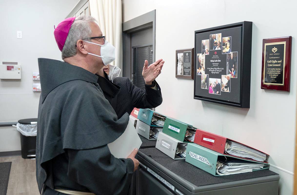 Charlotte Bishop-Elect Michael Martin, OFM Conv., visits the health clinic at Holy Angels. The clinic, named for the late Bishop William Curlin, enables Holy Angels to provide specialized care to its residents.