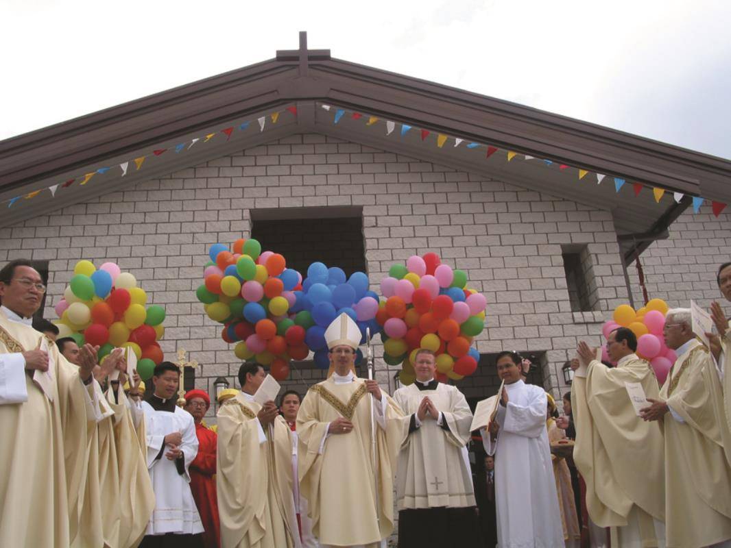 Bishop Jugis stands before St. Joseph Vietnamese Church in Charlotte at its dedication in 2004 