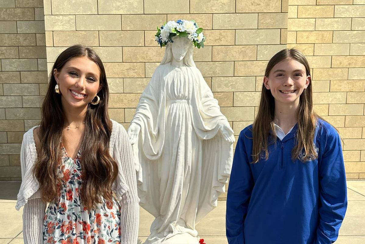In keeping with school tradition, the oldest and youngest Christ the King female students have the honor of placing the crown of flowers on Mary’s head.