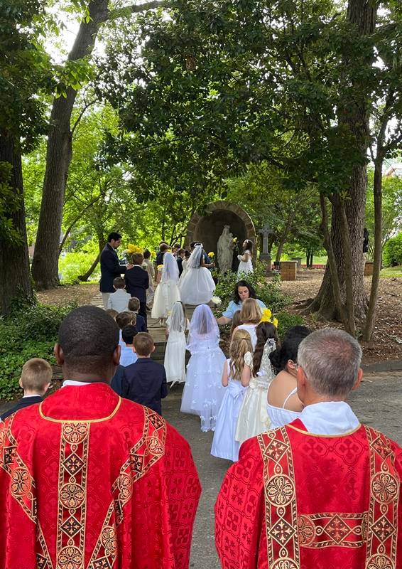 After Mass, 2nd graders that recently made their First Communion led the procession from the Cathedral to the school's own Marian grotto for the May Crowning.