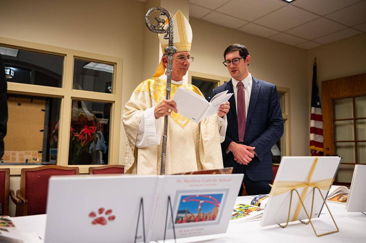 Bishop Jugis reviewing school books with Schools Superintendent Dr. Gregory Monroe.