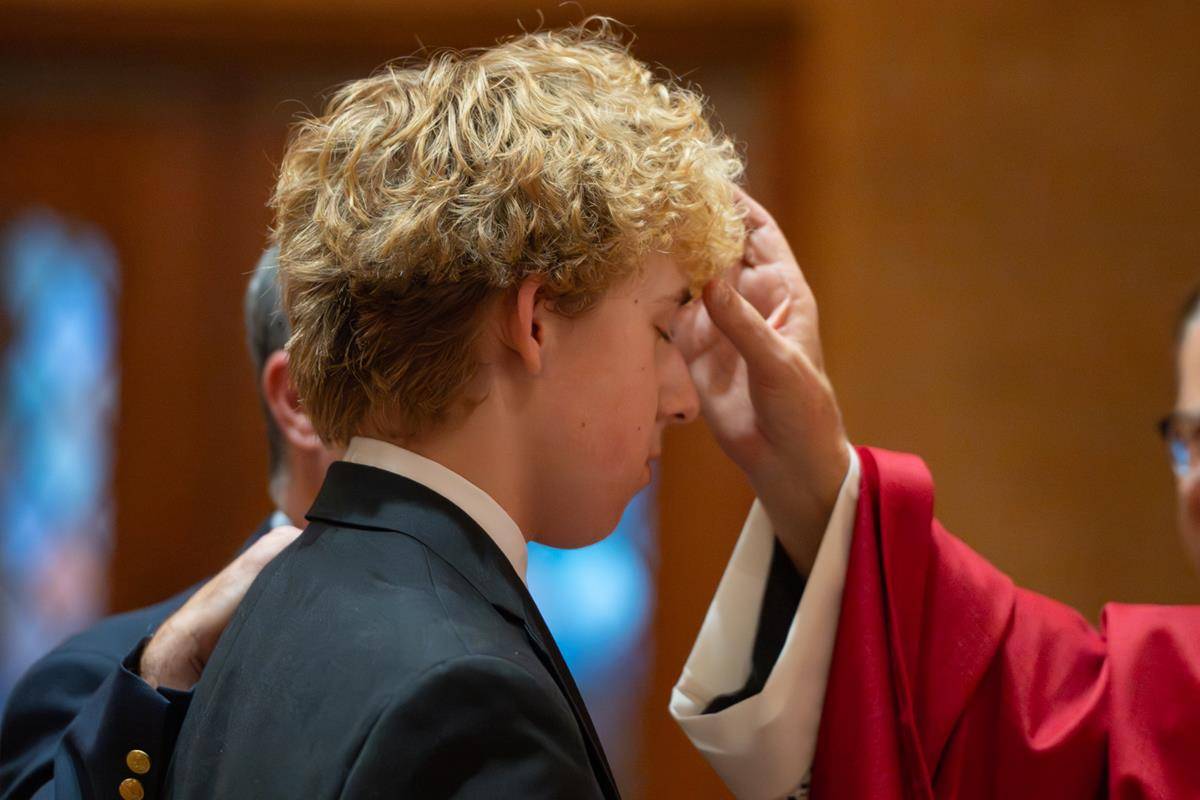 Bishop Martin confirms Matthew Johnston, a recent graduate of Our Lady of Grace School.