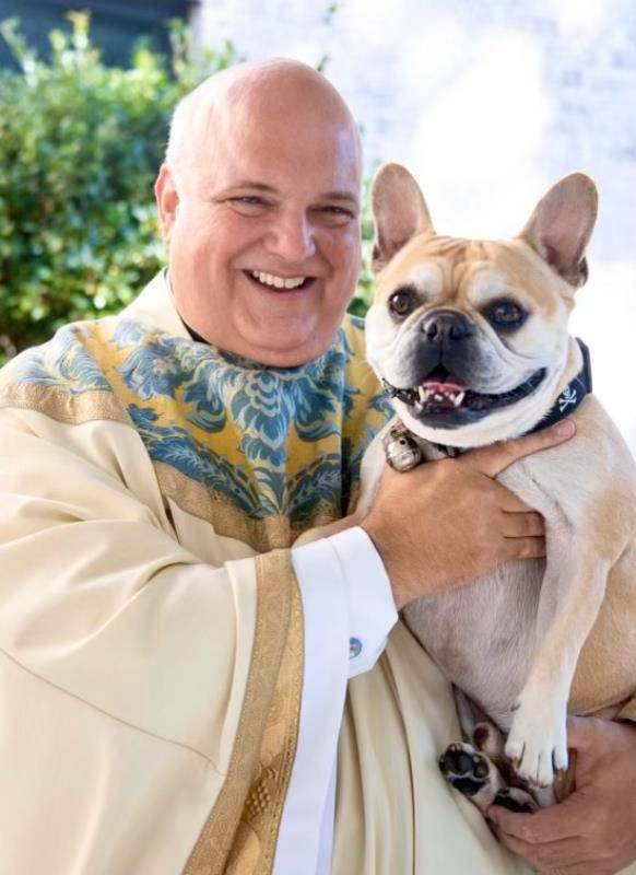 Tater was always the center of attention, posing here with his dad at St. Pius X’s annual pet blessing celebration in 2023. Tater is being well taken care of in Monsignor Marcaccio’s absence, spending time now with his littermate Beau.