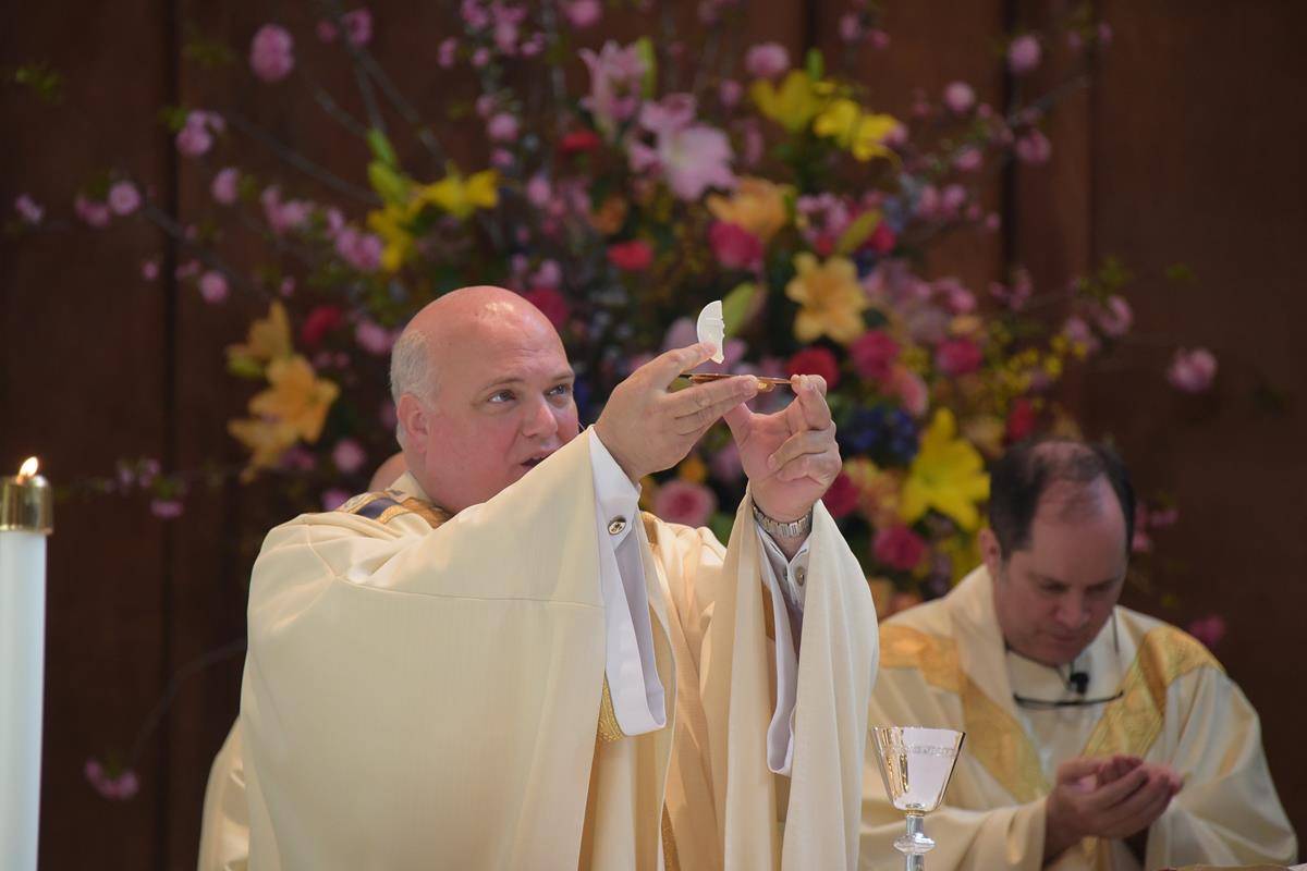 Holding up the Host at Easter Mass, Monsignor Marcaccio was “meticulous” about the liturgies and homilies he delivered, just as he was about the physical appearance of the St. Pius X campus.