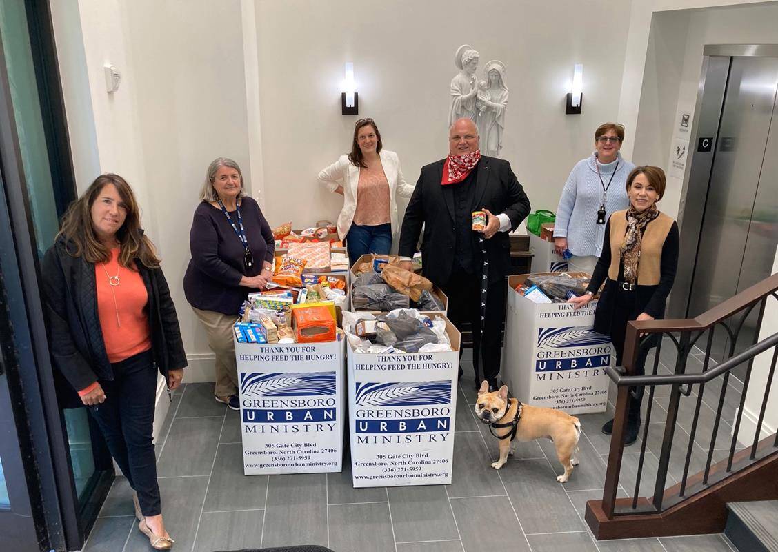 Parishioners and their pastor pose with a small sliver of the food collected for the poor on a Mother’s Day during the COVID-19 pandemic. The parish is a significant supporter of Greensboro Urban Ministry and its food pantry.