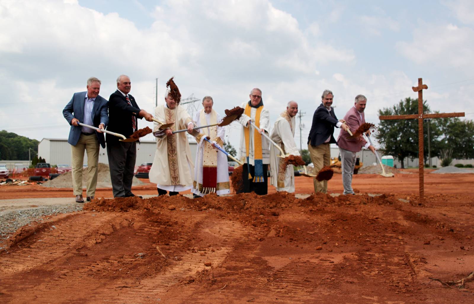 Bishop Martin, Monsignor McSweeney, Father Malacari, building project leaders, and parish leaders turn the dirt to officially break ground on the building project.