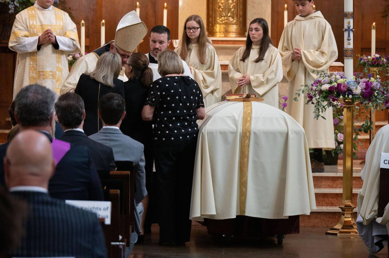 The offertory gifts are presented at the altar.