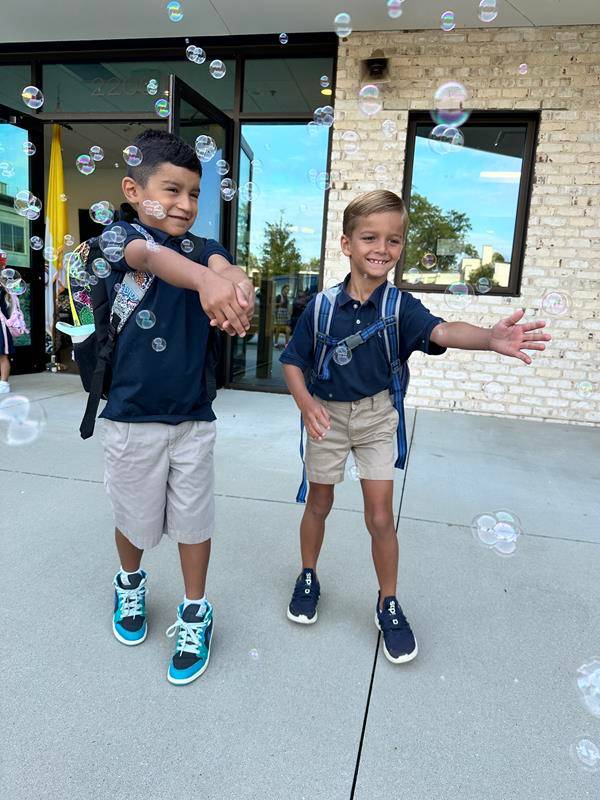 Students smile as they arrive at St. Pius X School in Greensboro for the first day of school.