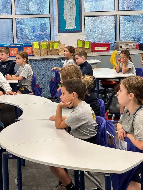 Students at St. Gabriel School in Charlotte watch a message from Bishop Martin on the first day of school. 