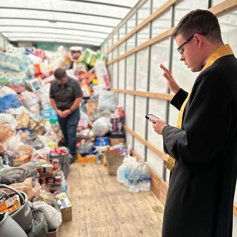 A load of supplies is blessed at Bishop McGuinness High School