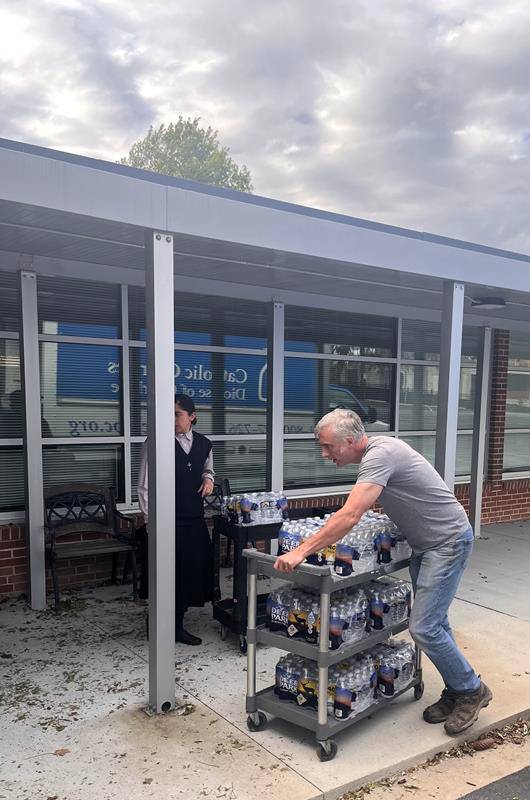 Volunteers deliver bottled water from Charlotte to Immaculata School in Hendersonville for distribution to people in need.