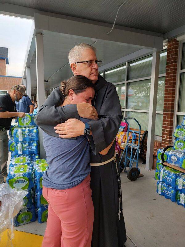 Principal Melissa Stuart gets a hug from Bishop Martin.