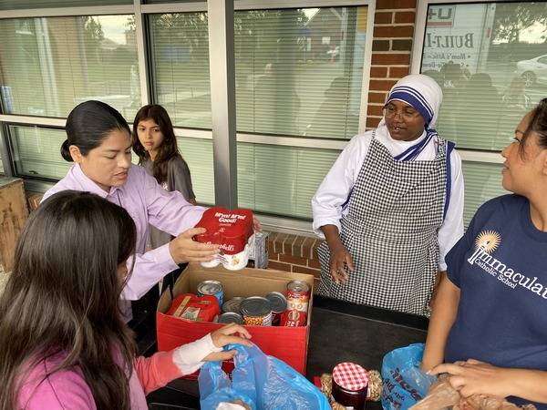 Missionaries of Charity work alongside local residents to distribute food and supplies.