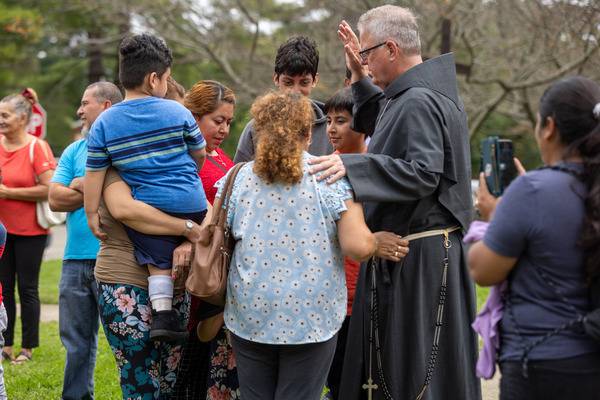 The bishop joined in prayer and offered spiritual consolation to those who had gathered on the church lawn. (Gabriel Swinney)