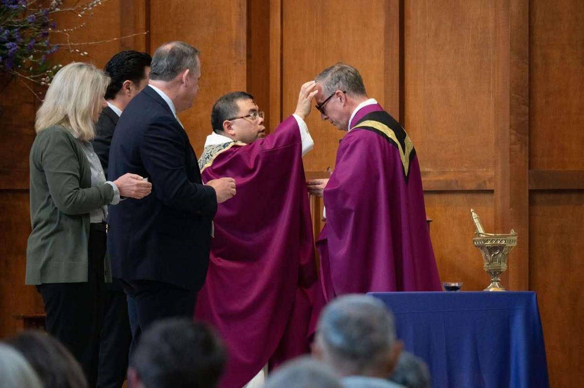 Father Christian Cook receives and distributes ashes on Ash Wednesday at St. Pius X Church in Greensboro. 