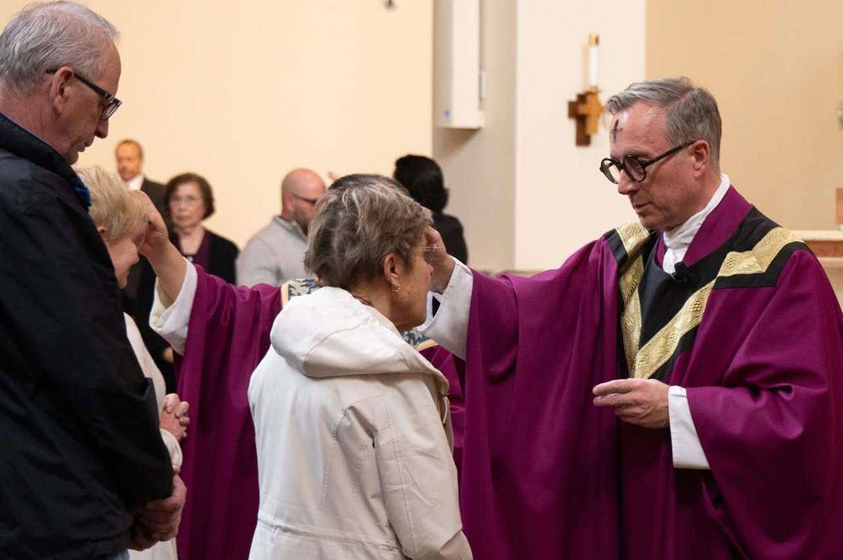 Father Christian Cook receives and distributes ashes on Ash Wednesday at St. Pius X Church in Greensboro. 