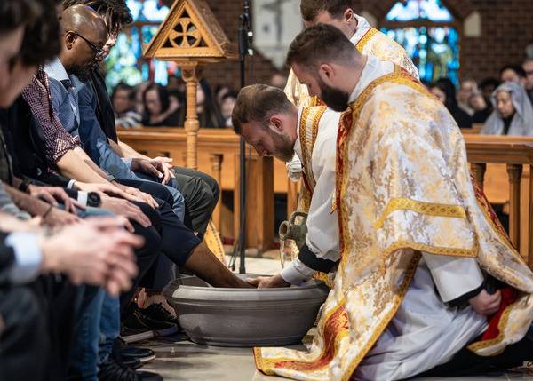 Father Matthew Harrison, parochial vicar, washes the feet of parishioners during Holy Thursday Mass of the Lord’s Supper at St. Thomas Aquinas Church in Charlotte. (Photo by Edward Chaplinsky Jr.)