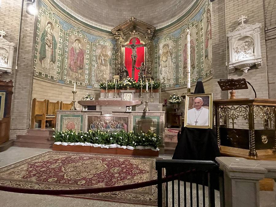 Portraits of the pope, which normally hang in the entryways of Catholic churches, were taken down, placed near the altar, and draped with black or purple bunting as a sign of mourning for the late pontiff. This one is from St. Lawrence Basilica in Ashevil