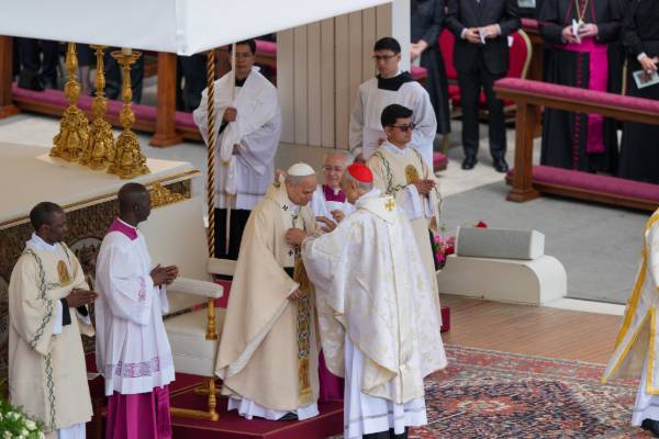 Pope Leo XIV receives a pallium, a woolen band symbolizing his role a shepherd of the universal church, from Italian Cardinal Mario Zenari during his installation Mass in St. Peter's Square at the Vatican May 18. (CNS/Kendall McLaren)