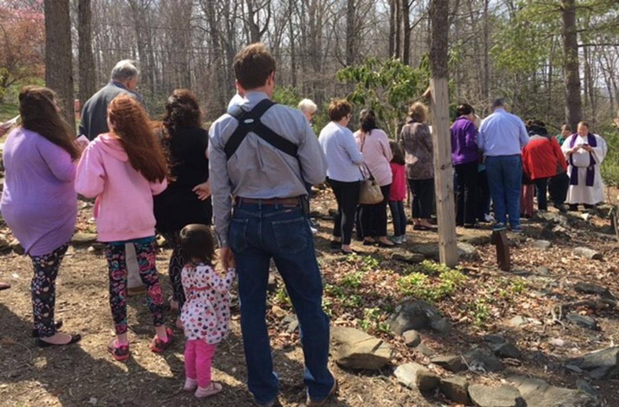 Parishioners of St. Francis of Assisi in Jefferson pray the Way of the Cross in outdoor prayer garden with Fr. James, pastor. (By Patrick Hession)